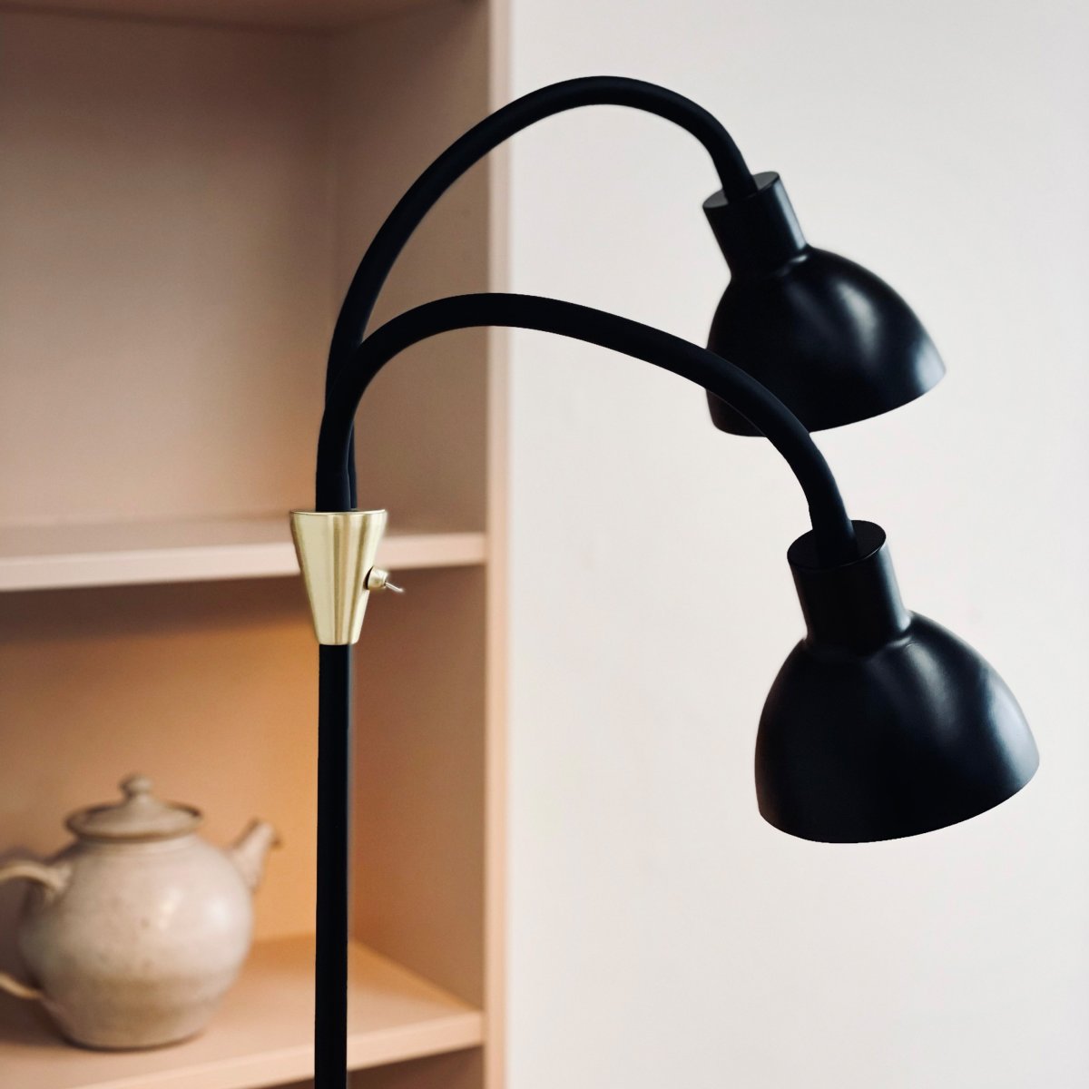 Lilje Negro lámpara de pie De Dyberg Larsen - Lily golvlampa i svart och m&auml;ssing kombinerar modern design med flexibilitet och funktionalitet.