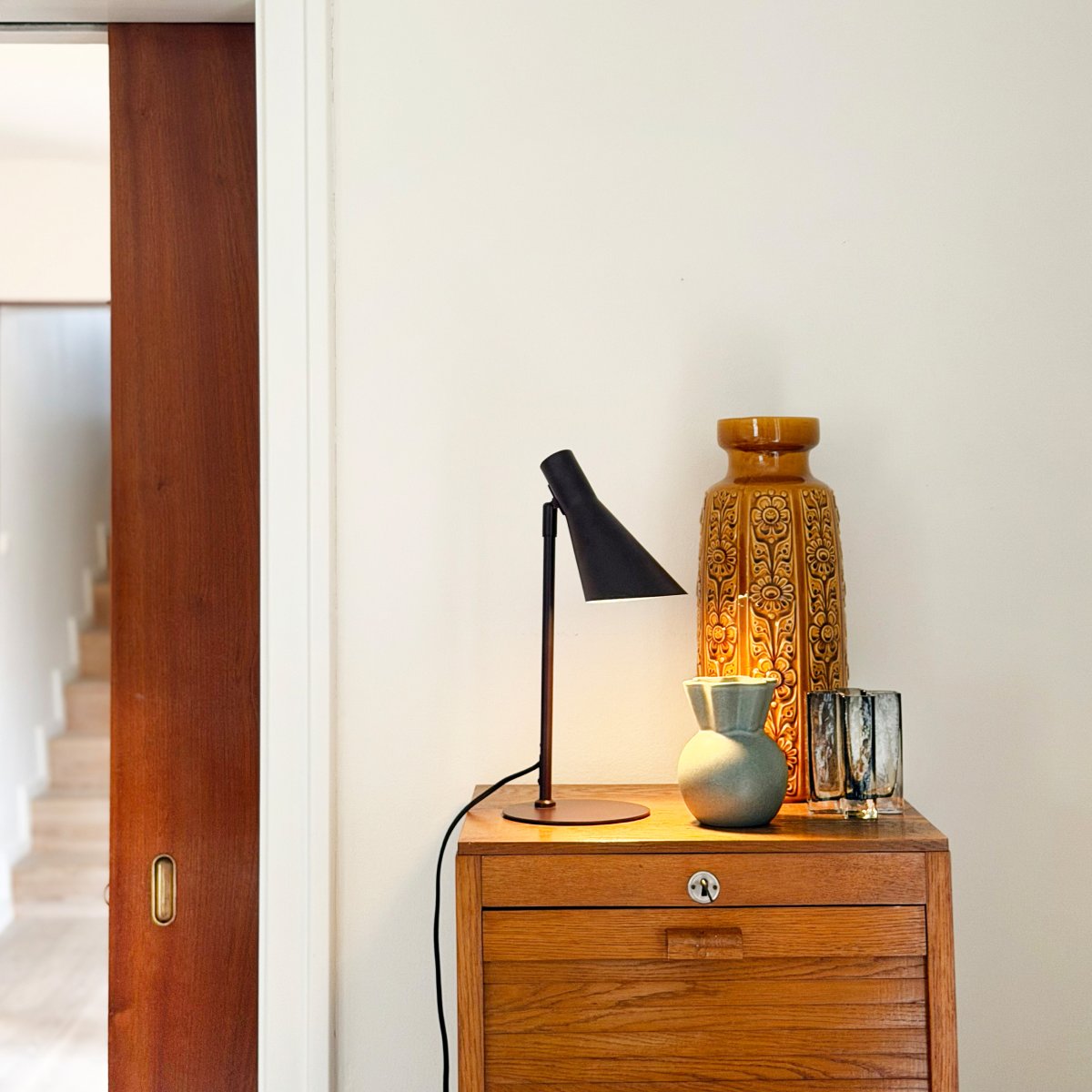 DL12 Mini 40cm Marrón lámpara de escritorio De Dyberg Larsen - Con sus l&iacute;neas gr&aacute;ficas distintivas y su silueta elegante, es perfecta para un escritorio en la oficina o como l&aacute;mpara de lectura en el sal&oacute;n o el dormitorio.