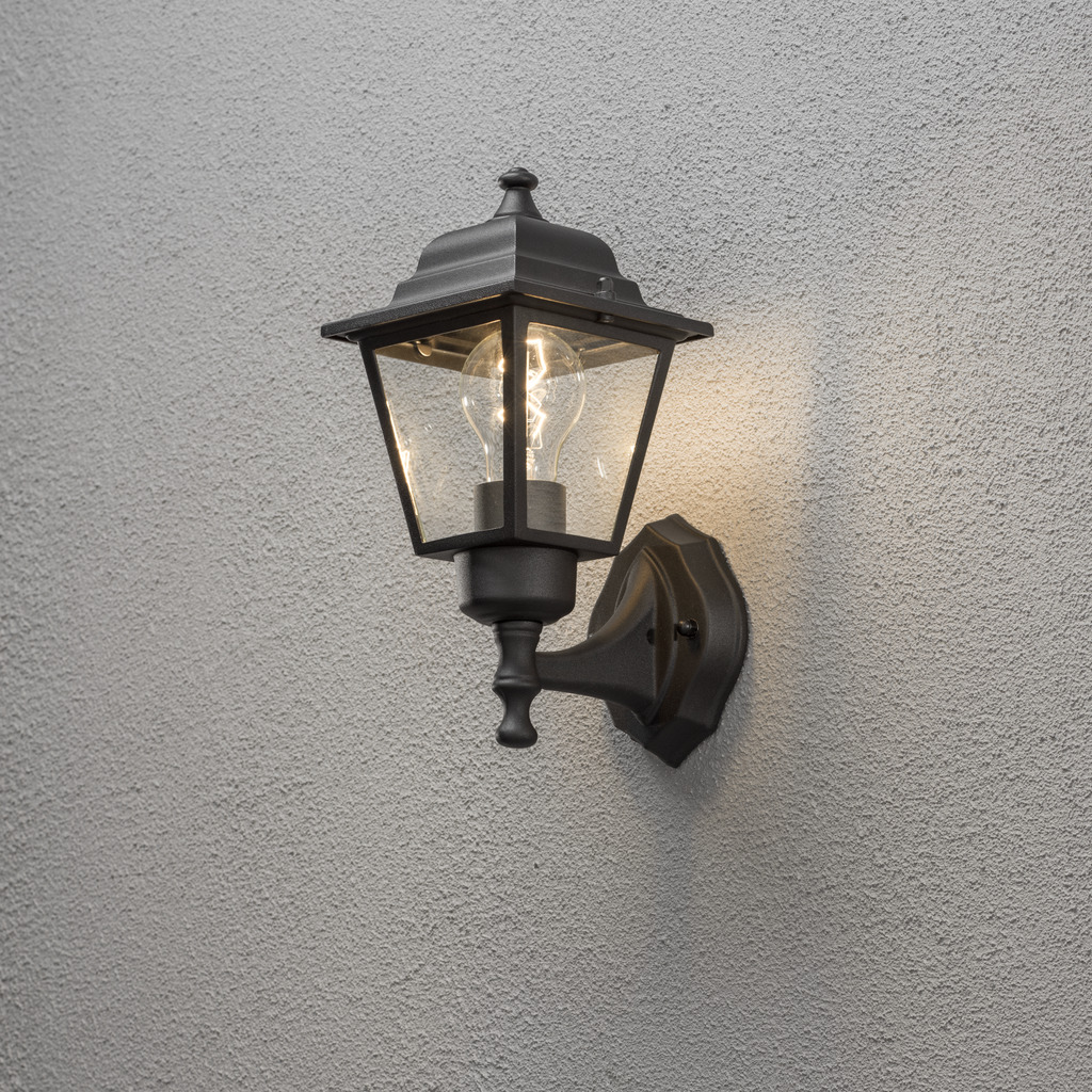 Vägglykta Negro lámpara de exterior De Konstsmide - Con su diseño en forma de linterna y paneles de vidrio transparente, la lámpara emite una luz cálida y acogedora que es perfecta para entradas, patios y pasillos.