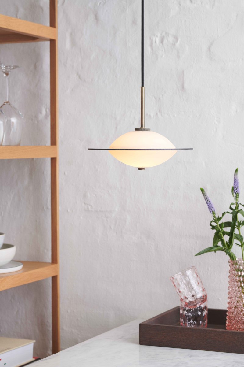 Orbit Ø24 Antigüedad Lámpas de techo De Halo Design - La forma redonda de cristal opalino proporciona una luz suave y atmosférica, mientras que los detalles en latón antiguo y cristal ámbar añaden un toque cálido y sofisticado.