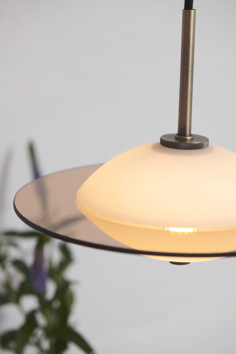 Orbit Ø24 Antigüedad Lámpas de techo De Halo Design - La forma redonda de cristal opalino proporciona una luz suave y atmosférica, mientras que los detalles en latón antiguo y cristal ámbar añaden un toque cálido y sofisticado.