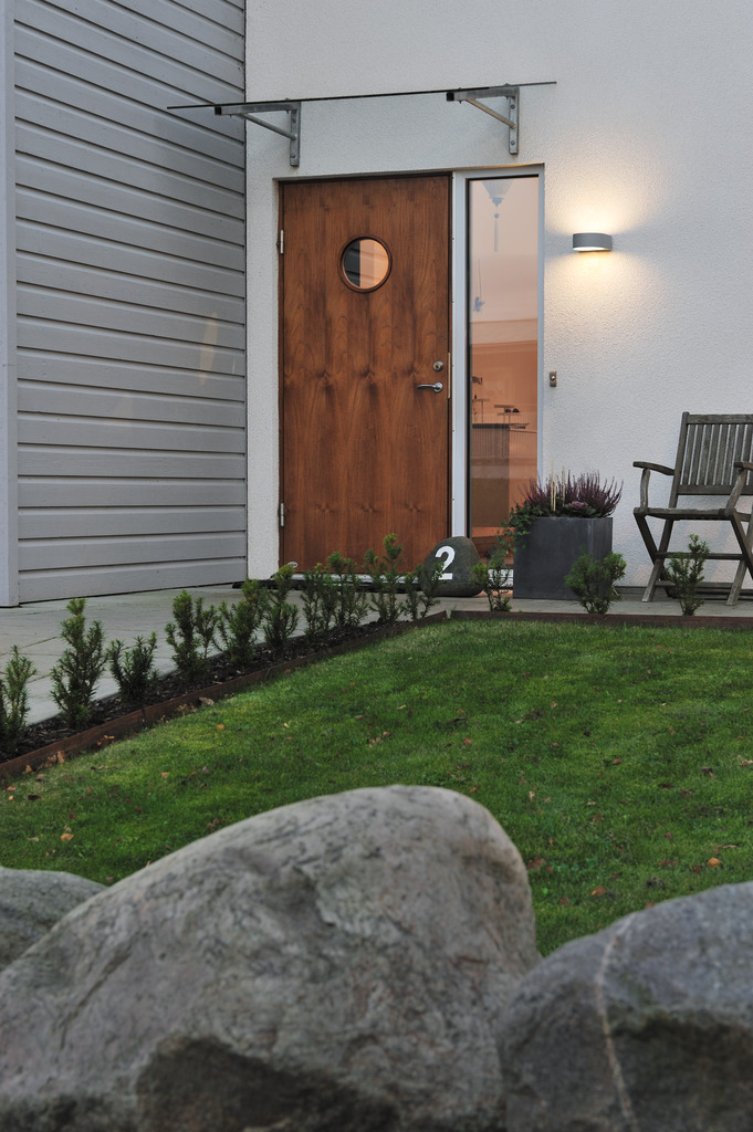 Teramo Gris lámpara de exterior De Konstsmide - El diseño minimalista con detalles de vidrio transparente añade un toque sofisticado y crea un hermoso juego de luz que resalta la fachada.