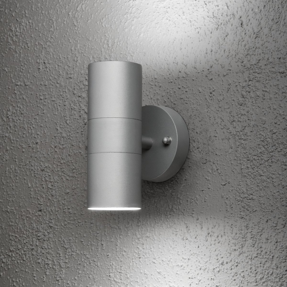 Modena Gris lámpara de exterior De Konstsmide - La luminaria emite luz tanto hacia arriba como hacia abajo, creando un efecto de iluminaci&oacute;n decorativa que realza la fachada y fomenta un ambiente exterior acogedor.