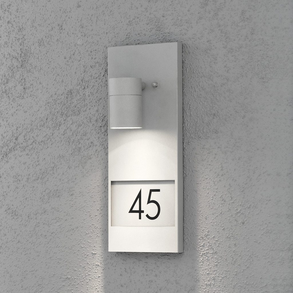 Modena Gris lámpara de exterior De Konstsmide - Esta luz de fachada con placa de número de casa ofrece una combinación perfecta de estilo y funcionalidad.