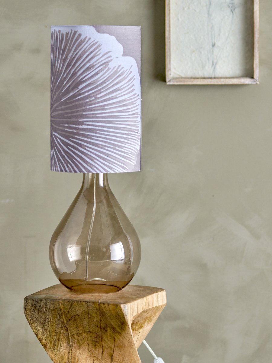 Leni 65cm Púrpura lámpara de mesa De Bloomingville - Su base de vidrio marr&oacute;n, de forma org&aacute;nica, irradia una elegancia et&eacute;rea, mientras que la pantalla cil&iacute;ndrica morada, adornada con un estampado floral blanco, le aporta encanto y personalidad.