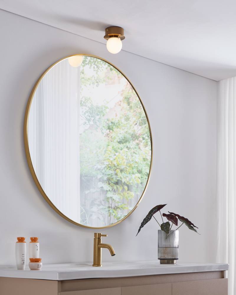 Mosiano Ø11 Oro lámpara de baño De Eglo - Con su pantalla de cristal suave y redonda y su base de metal de color dorado, crea una luz cálida y acogedora, perfecta para espacios más pequeños como pasillos o baños.