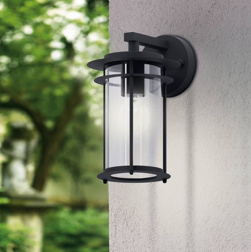Valdeo Negro lámpara de exterior De Eglo - La l&aacute;mpara presenta un elegante marco de acero galvanizado negro y un cilindro de vidrio transparente que rodea la fuente de luz, proporcionando una iluminaci&oacute;n agradable y acogedora.