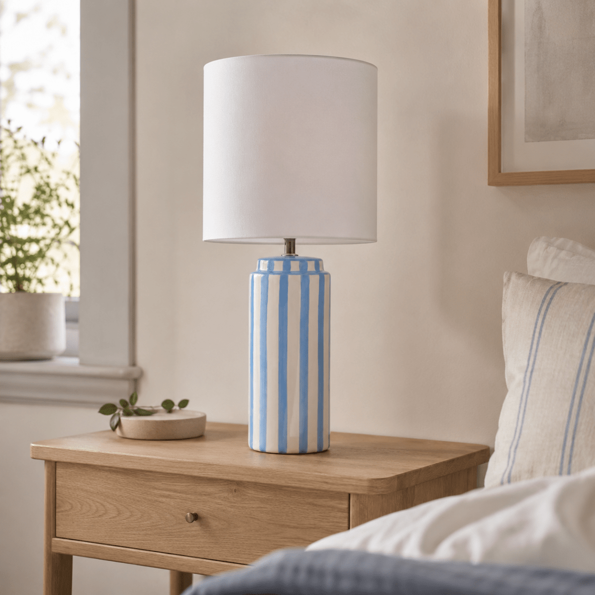 Faro 50cm Azul claro/blanco lámpara de mesa De Nordic Lighting - La base de cer&aacute;mica es de color blanco crema con rayas azul claro, creando un aspecto vibrante y armonioso.
