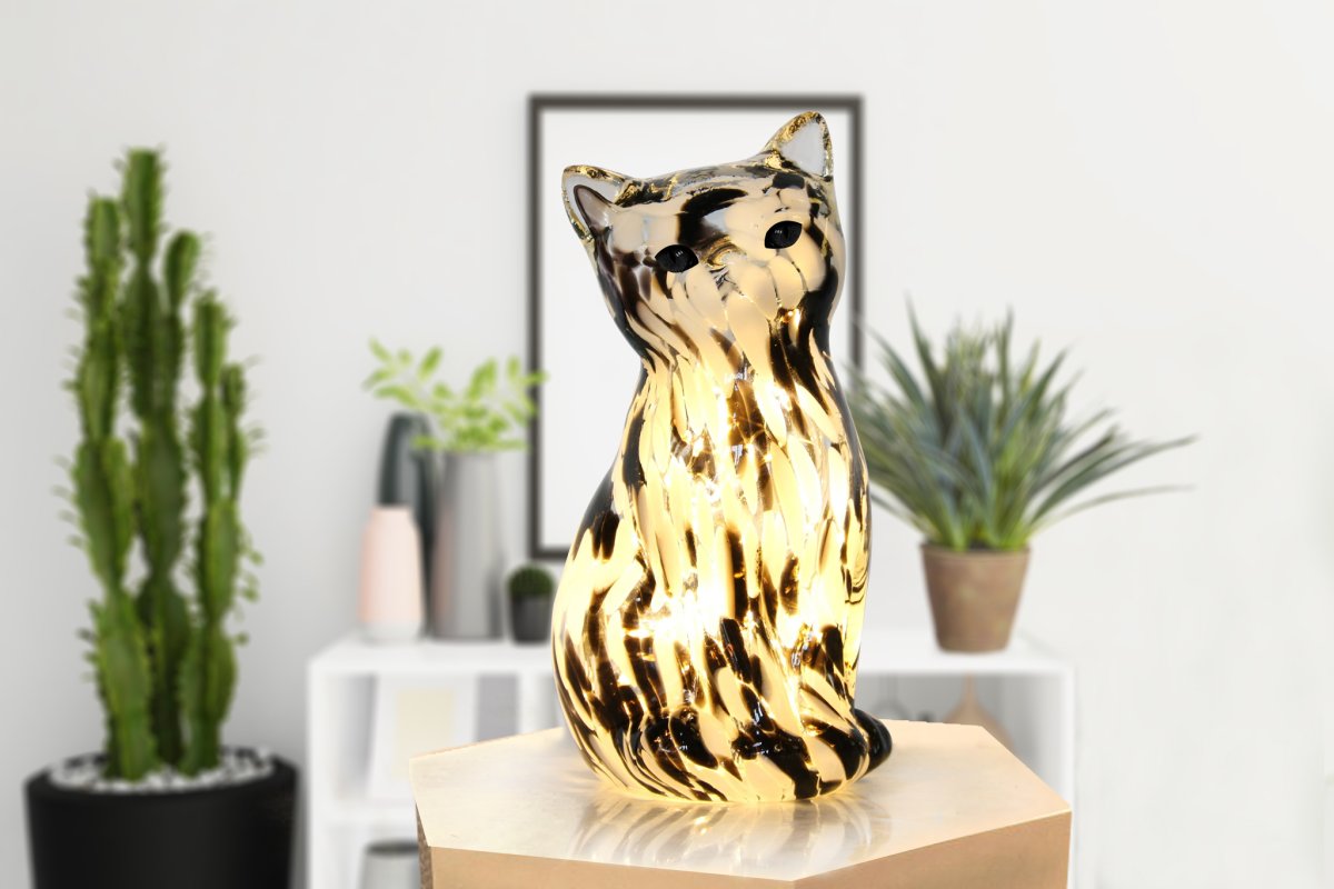 Katt 22cm En blanco y negro lámpara de mesa De Pixie Design - Esta l&aacute;mpara de mesa decorativa de cristal con forma de elegante gato cautiva con su superficie jaspeada en blanco y negro, lo que le otorga a cada pieza un car&aacute;cter &uacute;nico.