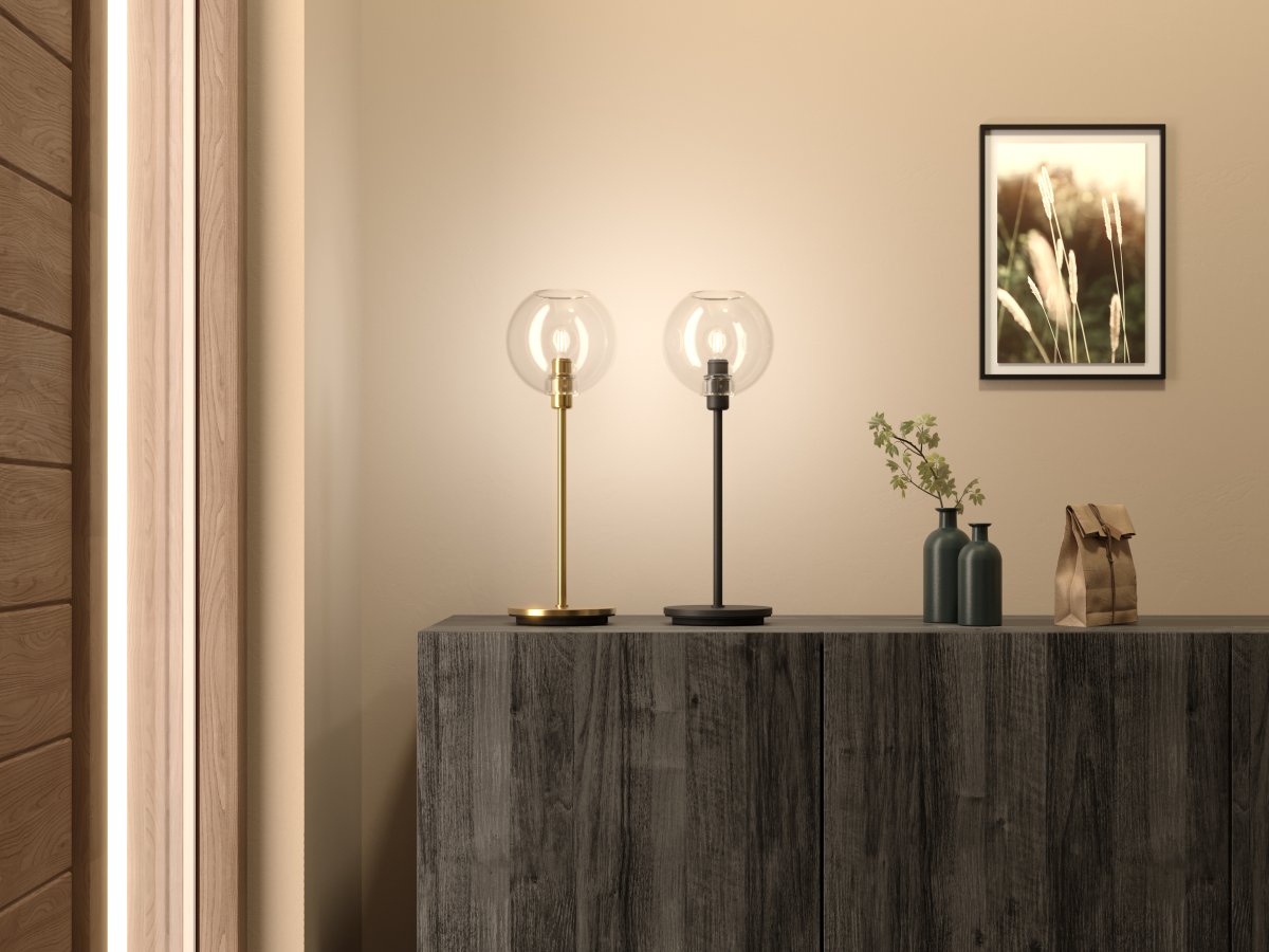 Gloria 46cm Latón/transparente lámpara de mesa De Belid - Gloria tiene un dise&ntilde;o simple y elegante con una base de l&aacute;mpara de metal y una pantalla redonda de cristal.