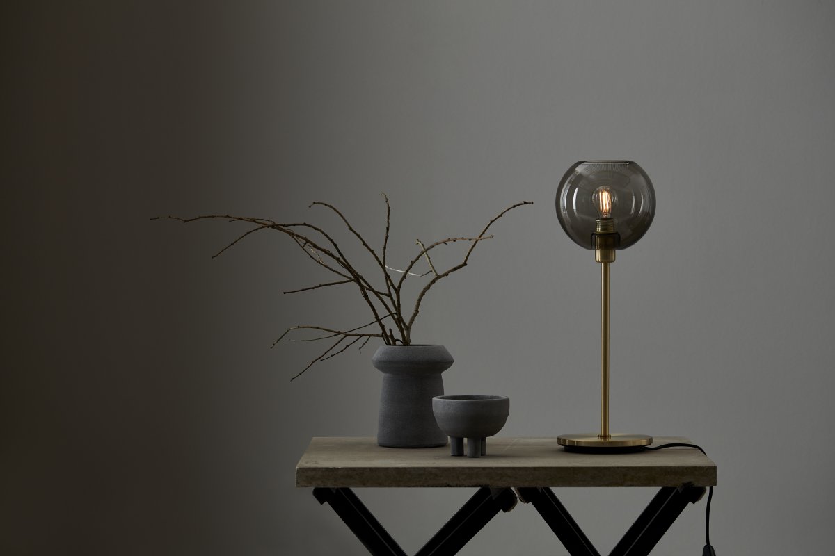 Gloria 46cm Latón/humo lámpara de mesa De Belid - Gloria tiene un dise&ntilde;o simple y elegante con una base de l&aacute;mpara de metal y una pantalla redonda de cristal.