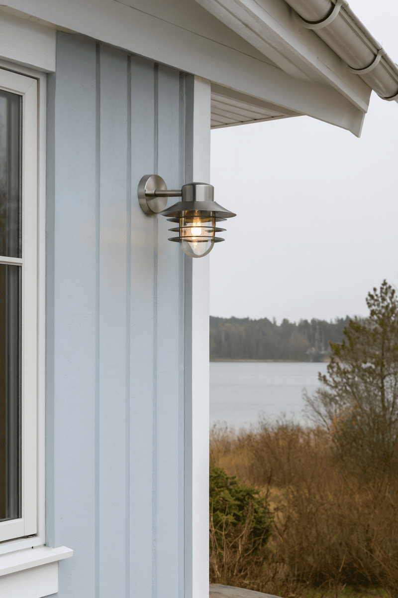 Ystad acero cepillado lámpara de exterior De Nordic Lighting - El aplique de pared Ystad es una l&aacute;mpara de exterior cl&aacute;sica y elegante, fabricada en acero inoxidable con cristal transparente.