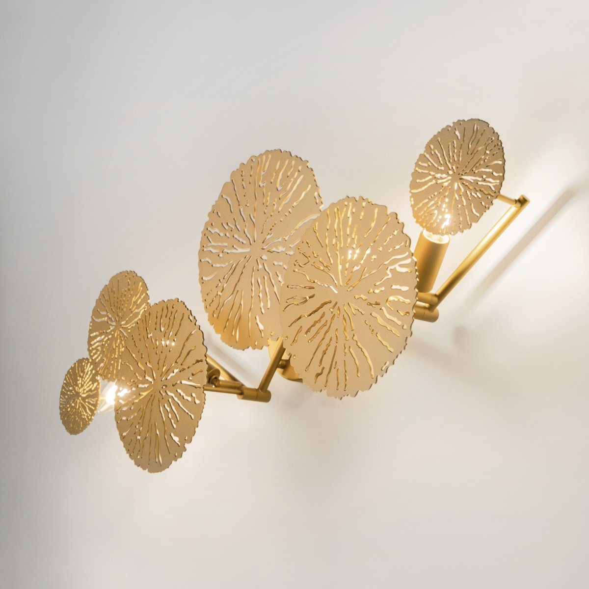 Lovetann 77cm Oro lámpara de pared De Maytoni - Los discos de metal con forma de encaje, que recuerdan a los dientes de león, crean un hermoso patrón de luz en la pared gracias a su diseño perforado.