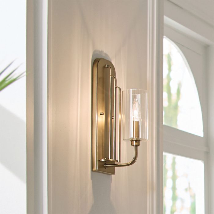 Kimrose 35cm Latón cepillado lámpara de pared De Elstead Lighting - La pantalla de vidrio cil&iacute;ndrica es transparente y presenta ranuras verticales que crean un efecto de iluminaci&oacute;n &uacute;nico y sutil.