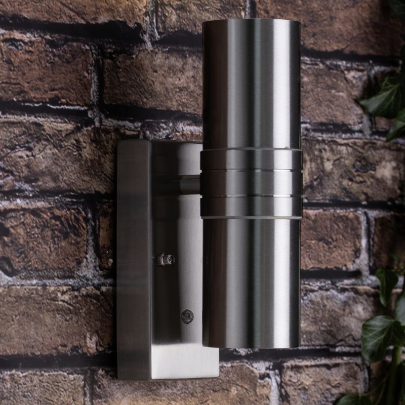Hanni Acero lámpara de exterior De Brilliant - El aplique de exterior Hanni está diseñado para la iluminación decorativa, transformando una fachada sencilla en una pequeña obra de arte de luces y sombras.