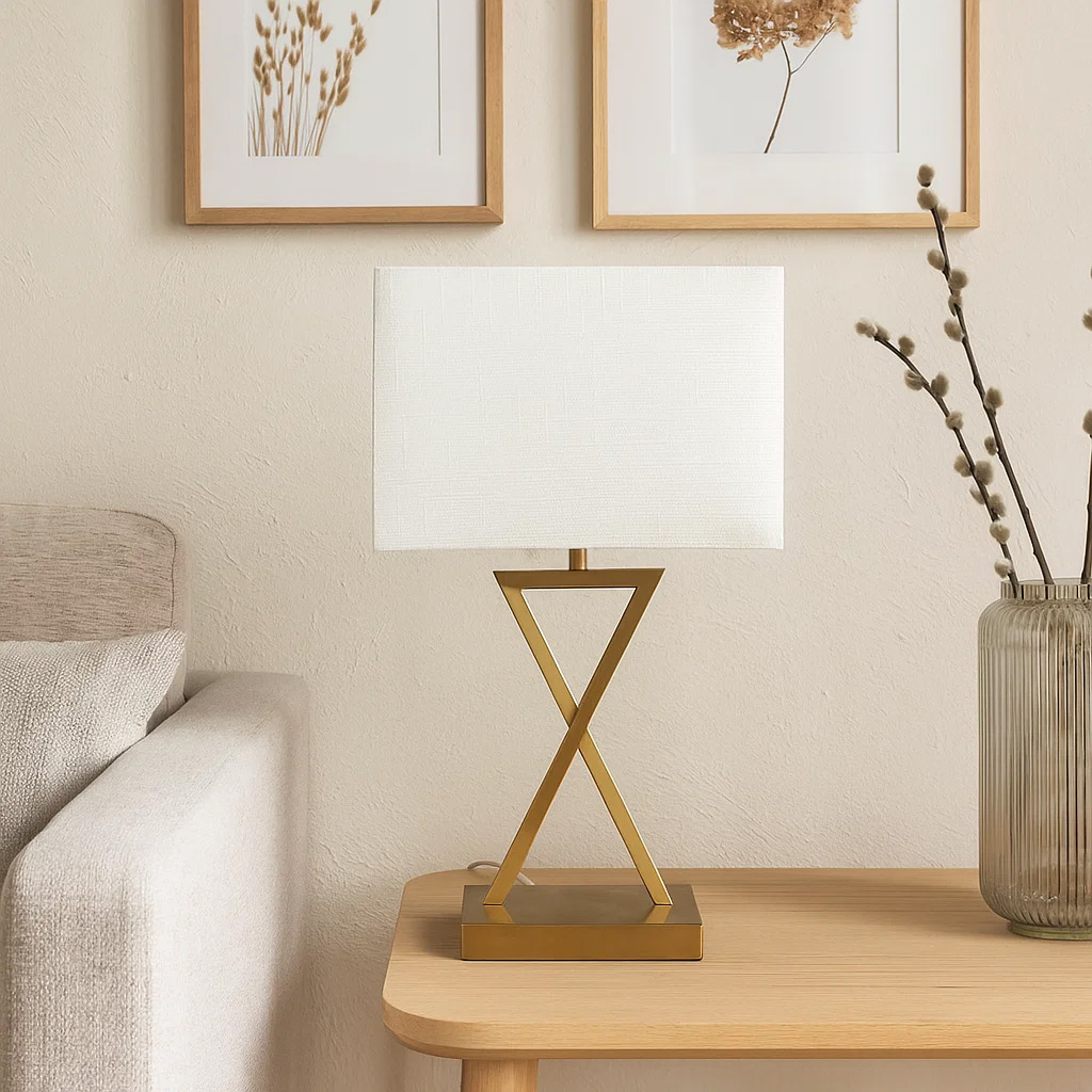 X-factor 54cm Latón lámpara de mesa De Nordic Lighting - La l&aacute;mpara de mesa X-Factor combina una moderna base met&aacute;lica geom&eacute;trica con un elegante acabado en lat&oacute;n y una pantalla de lino blanco.